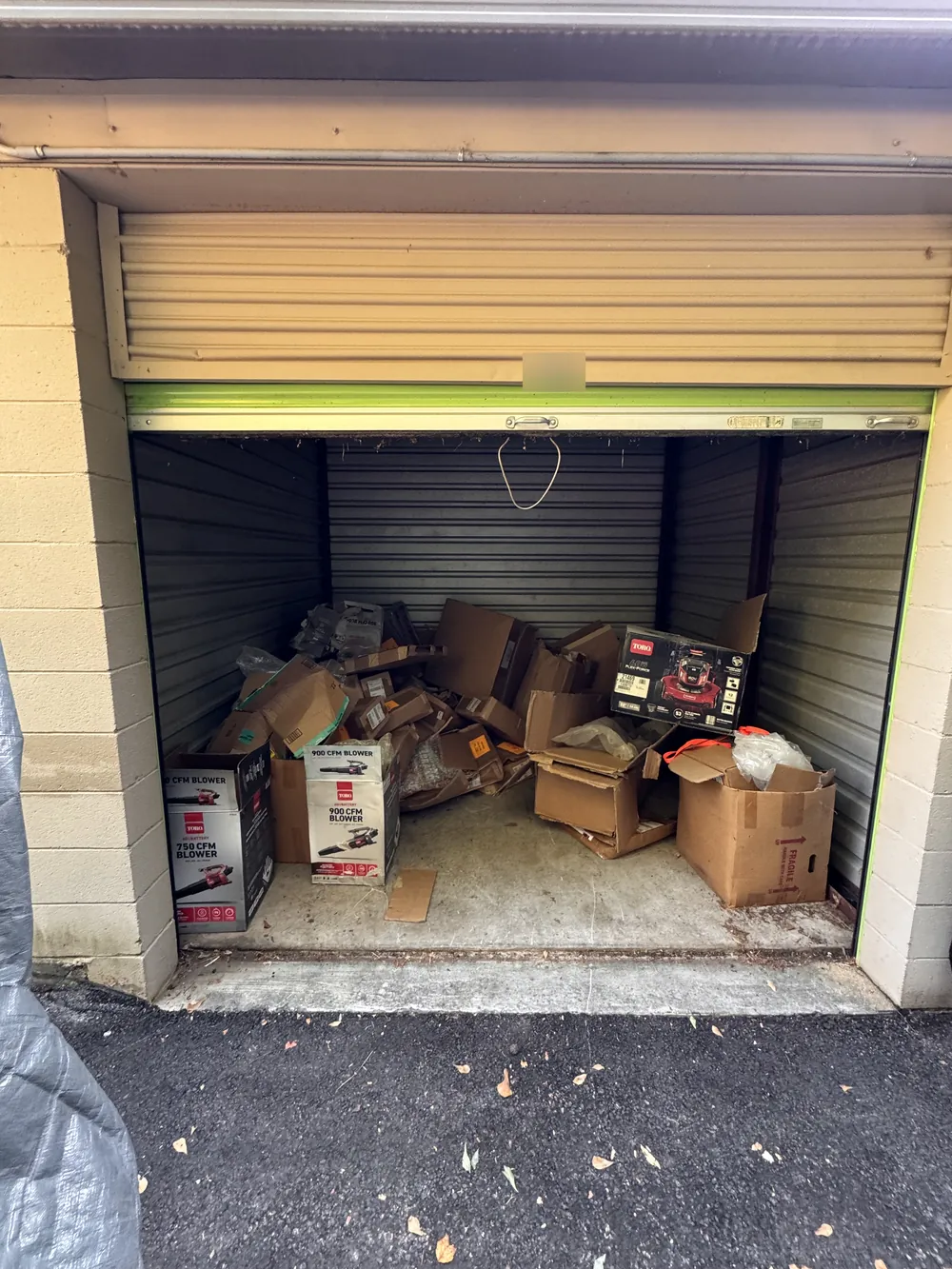 A storage unit filled with flattened cardboard and equipment boxes before a cleanout
